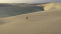 A Pretty Girl Walking On Sand Dunes During Sunset In Brazil