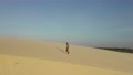 An Aerial Rotation Shot Of A Man Walking On Sand Dunes In Brazil