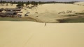 A Girl Wearing A Bikini Walking On Sand Dunes