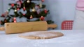 Rolling Pin And Gingerbread Dough On Table On Christmas Tree Background.