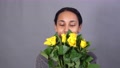 Closeup Of Smiling Mixed-Race Young Pretty Woman With Bunch Of Yellow Roses