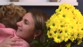 Caucasian Mother And Daughter Are Embracing With A Bunch Of Flowers Smiling And